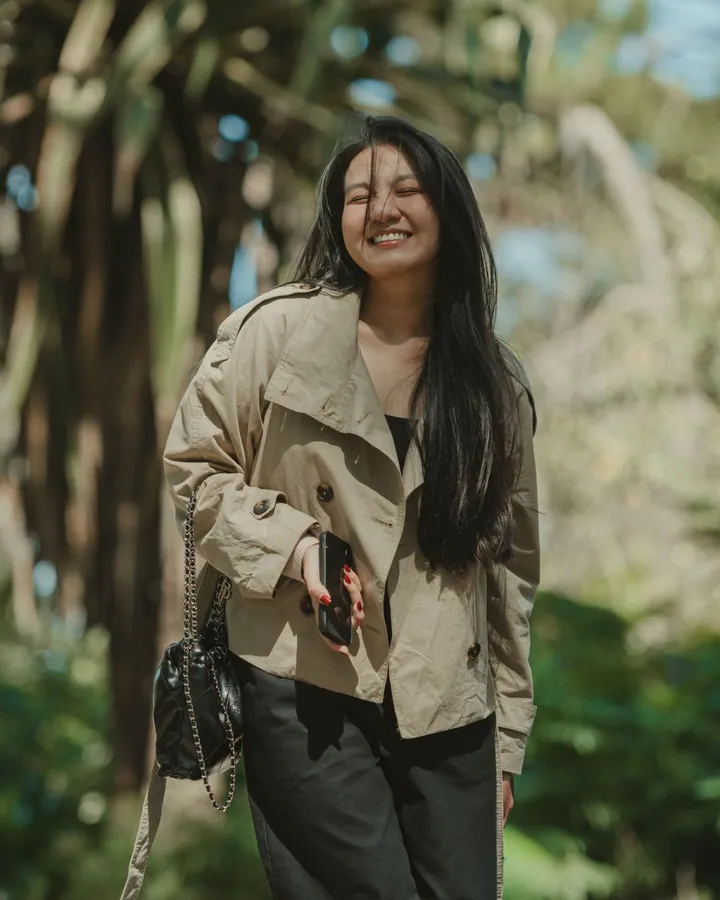 Une femme marche sereinement dans un jardin