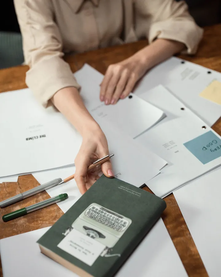 Des mains parcourent des documents sur un bureau