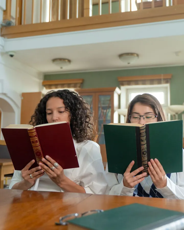Deux femmes lisent dans une bibliothèque